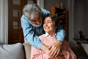 Elderly couple smiling in cozy home | Clear Tone Hearing Aids