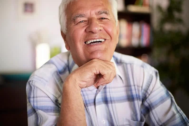 Smiling older man seated indoors